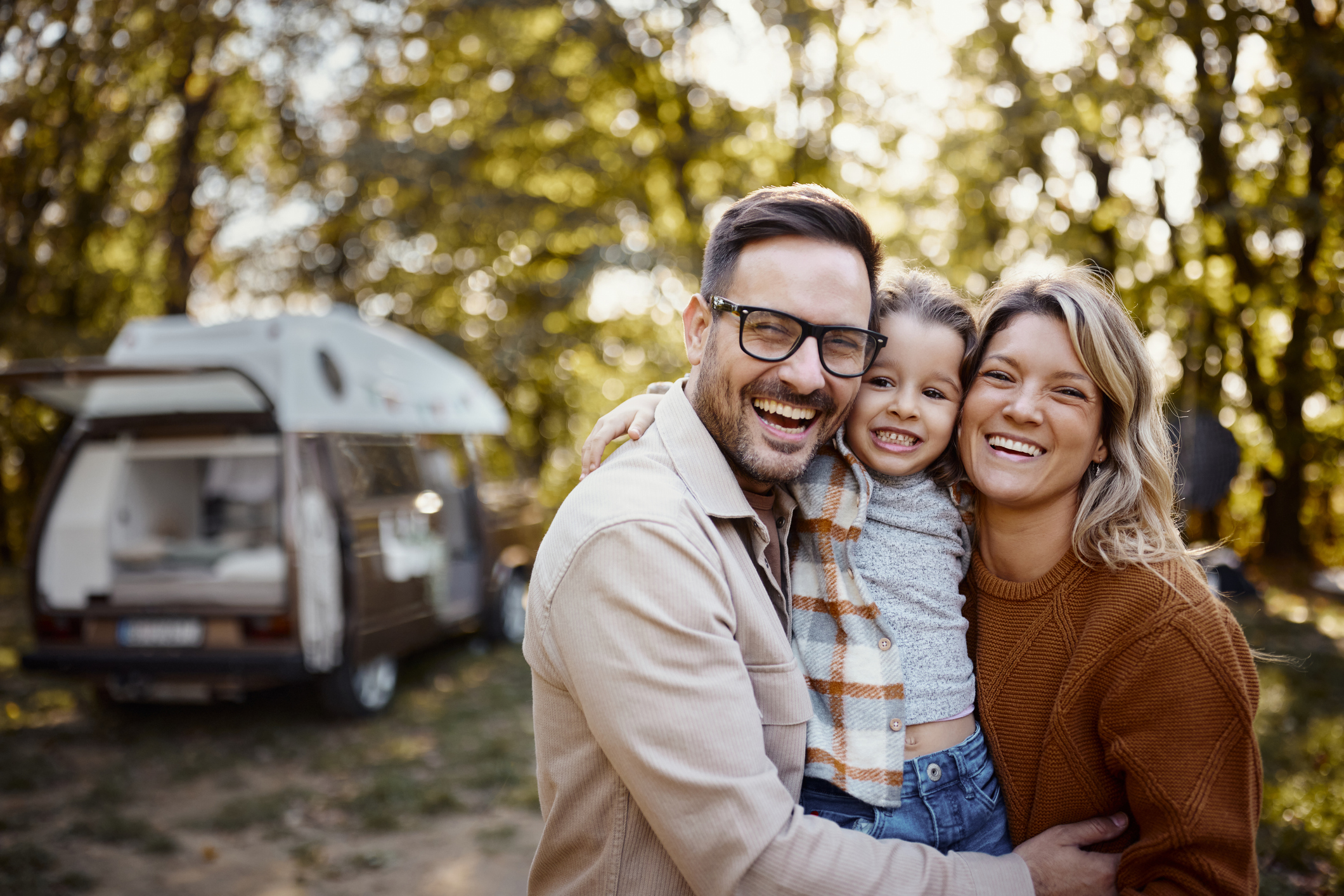 Happy family enjoying a camping trip in the forest with RV