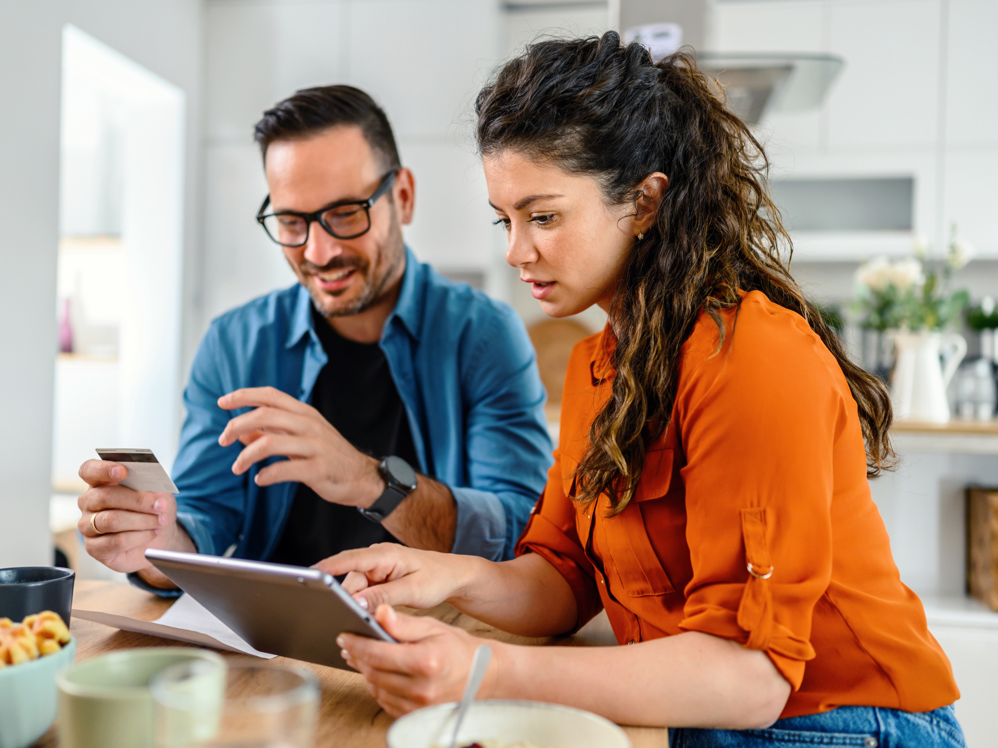 Couple shopping online with tablet and credit card at home