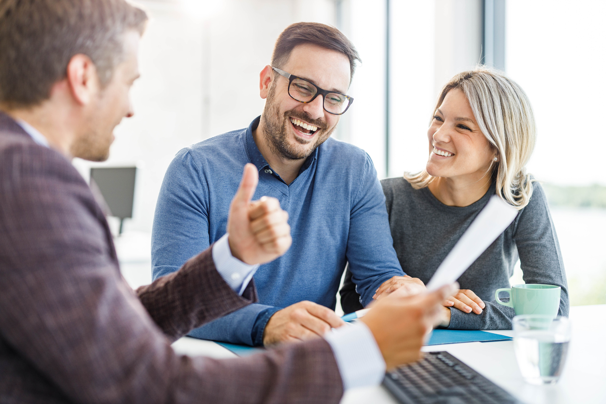 Happy couple discussing financial planning with advisor