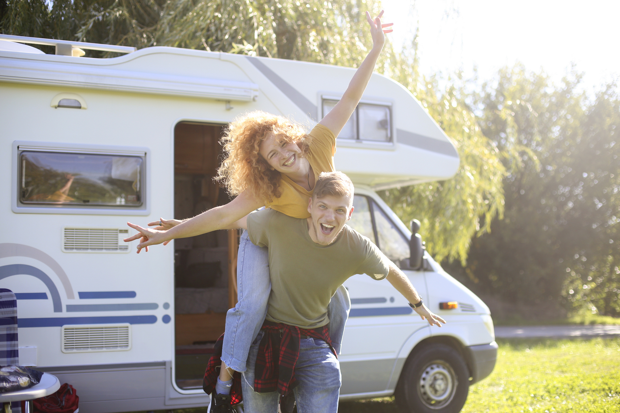 Happy couple enjoying road trip by RV in sunny countryside